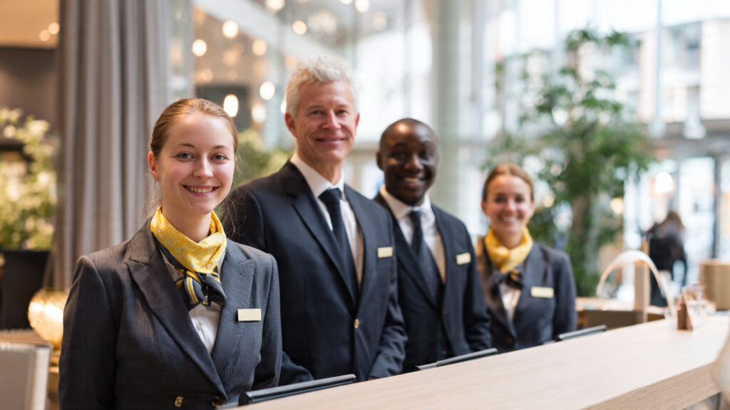 Work In Norway Hotel Hospitality Career Options And How To Apply A realistic photograph of a modern Norwegian hotel lobby with hotel staff assisting guests.